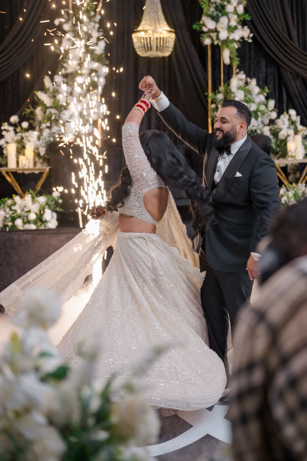 Groom in a black Super 140s merino wool shawl-lapel tuxedo dancing with his bride