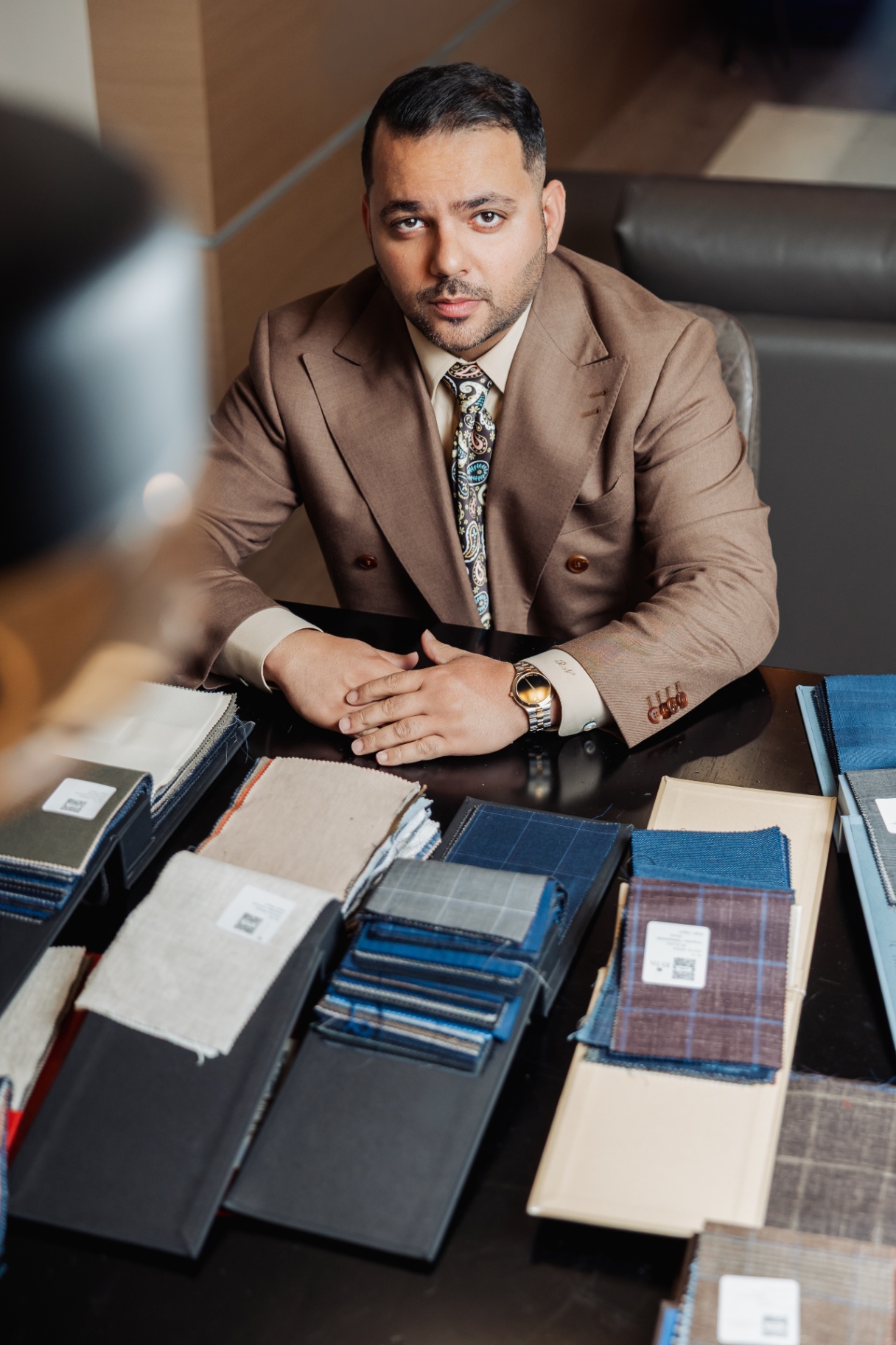 Rajat Nagpal with hands folded over curated bespoke fabric books