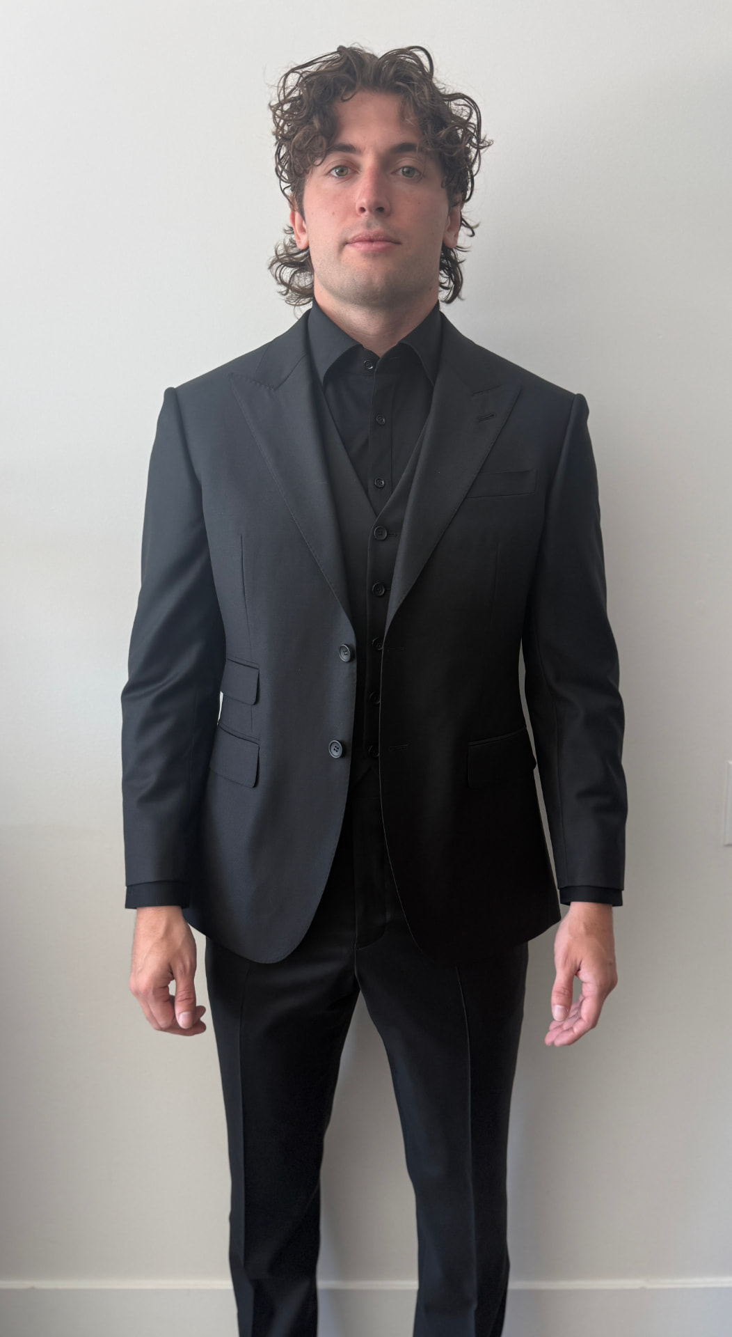 Client in a Guabello 3-piece black wool suit against a clean studio backdrop